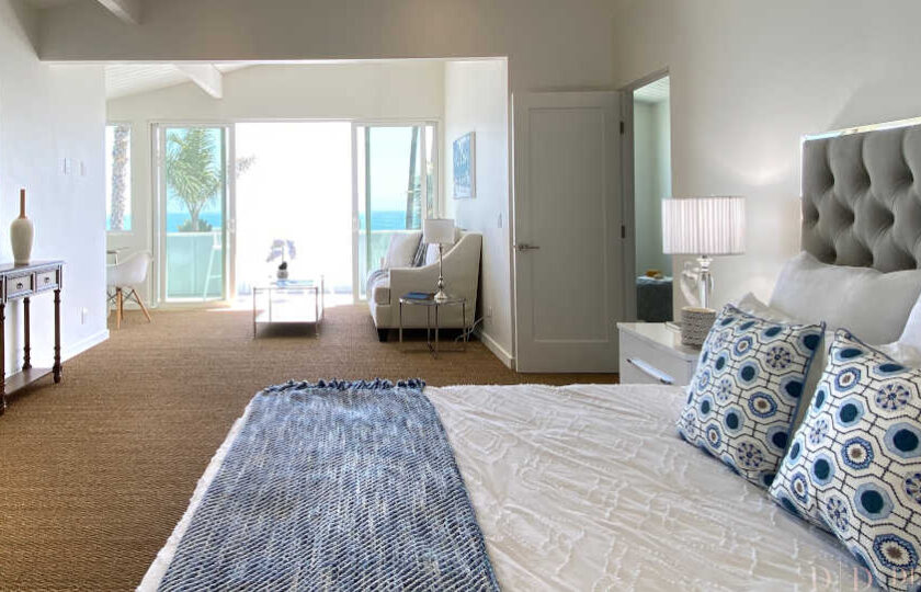 Boho Chic beach house home staging at Faria Beach, master bedroom shot facing over king bed towards sitting area and balcony