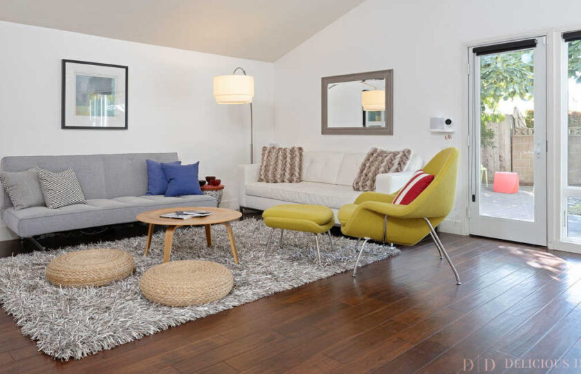 Mid century modern living room scene facing grey and white sofa touching in the corner