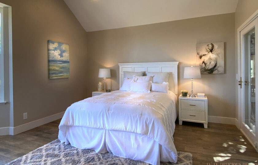 Master bedroom setting facing bed with painting of woman's back to the right
