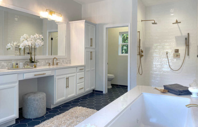 Master bathroom with white orchid on sink counter on the left and decor surrounding tub to the right