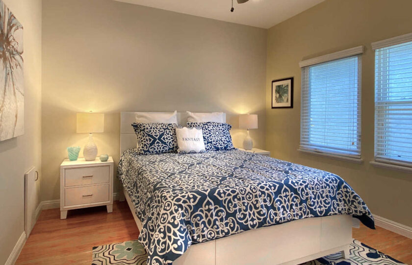 Guest bedroom with white headboard and blue and white bedding decor