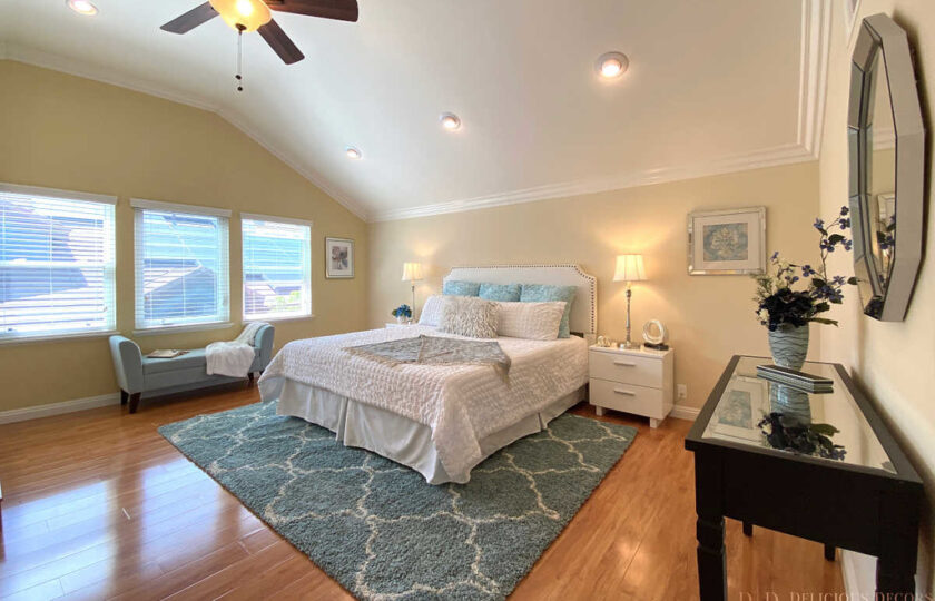 Master bedroom with white king bed with light blue accents