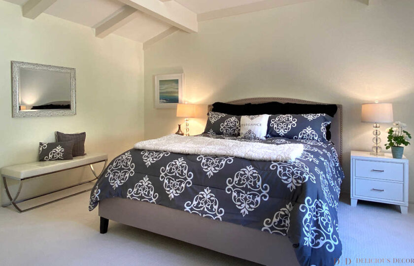 Detail of master bedroom with gray king bed with damask bedding