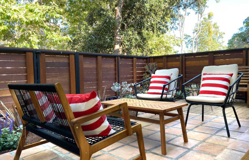 Outdoor patio decorated with bench and two chairs and an outdoor table