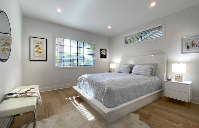 Guest bedroom with a white headboard and light gray bedding