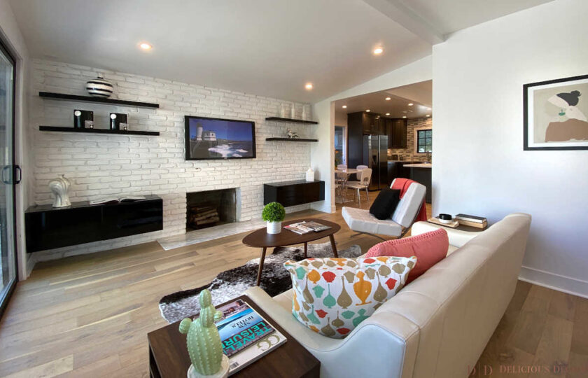 Family room with white sofa and tv wall with shelves