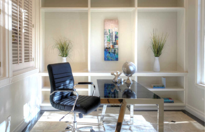 Office with black contemporary desk and desk chair and abstract painting on the wall