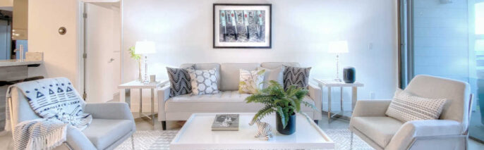Living room home staging in Brentwood condo direclty facing sofa, two occasional chairs, and art with bicycles