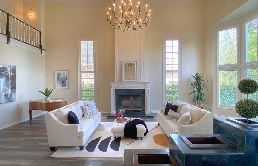 Traditional home staging designed living room featuring two white with silver-nail heads sofas over an ivory are rug