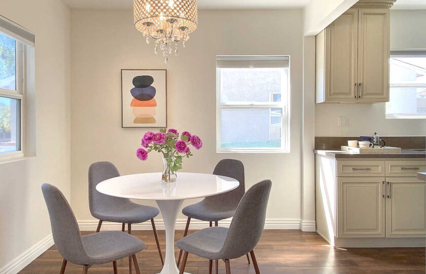Kitchen-dining home staging with a white acrylic tulip table and grey dining chairs