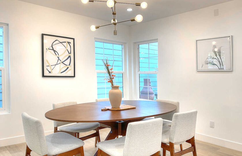 Dining room with oval walnut table and white upholstered dining chairs