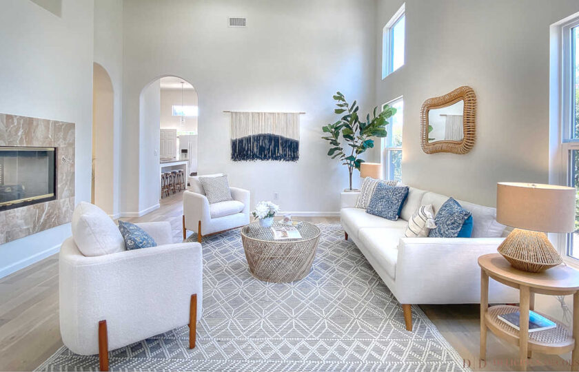 Living room home staging design featuring two sherpa fleece accent chairs, white modern sofa from Article, and macrame art hanging on the wall