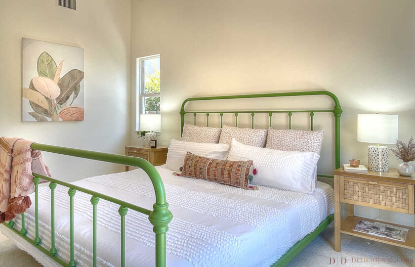 Meadow green metal platform king bed with open footboard and headboard in primary bedroom