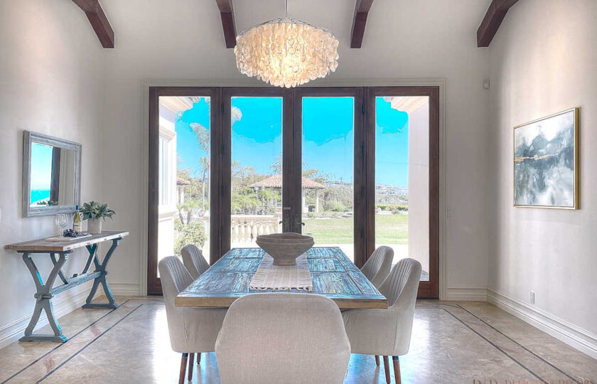 Home staging a modern traditional Malibu compound includes a rustic oak dining table with views to the ocean.