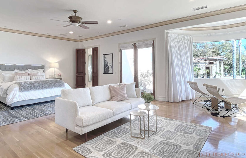 Primary bedroom with king bed, sofa in foreground and lounge chairs in oval area is dreamy. It's all part of the home staging a modern traditional Malibu compound.