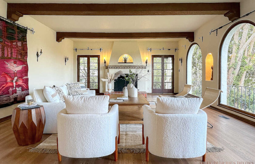 Living room staging showing two fleece Sherpa accent chairs facing fireplace in Spanish-Colonial home