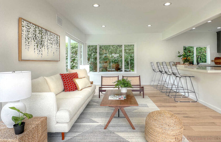 Malibu woven accent cubes, rattan pouf, and cane-backed lounge chairs soften the distinctively modern home staging design.