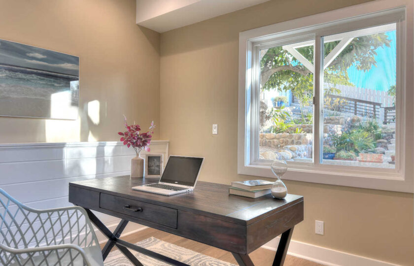 Home office features a farmhouse desk and fun office chair to bring out some charm.
