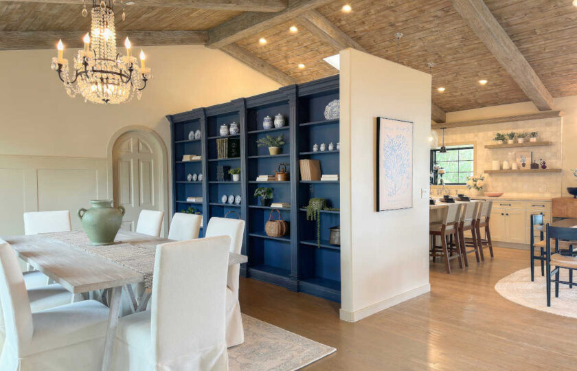 Modern farmhouse luxury staging is exemplified in this dining room, featuring a distressed oriental rug, slip-cover dining chairs, and a white-washed extra long dining table.