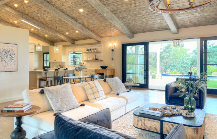 The great room has a candelabra chandelier, exposed wood beam ceilings, and plenty of square footage!