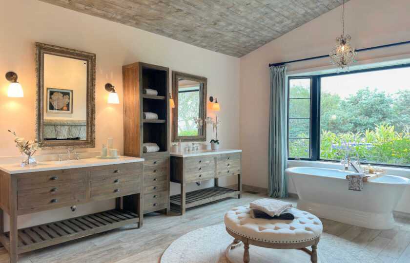 Primary bathroom with a tufted top circular ottoman over a circular wool rug.