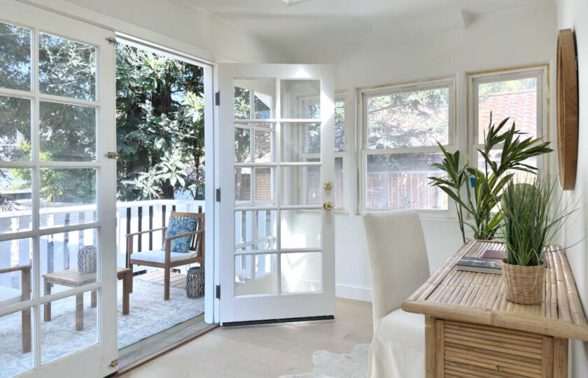 Bamboo desk with a slip-cover dining chair tucked in, all over a ivory faux hide rug add a chic yet coastal vibe to this remodeled Santa Barbara craftsman home staging design