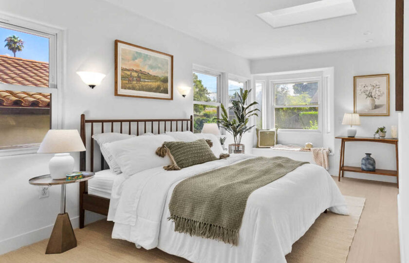 Casual primary bedroom home staging design in Santa Barbara craftsman with modern walnut spindle bed, bedding turned down