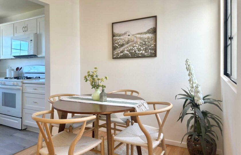 The small dining space uses oak wishbone dining chairs with a walnut veneer circular dining table.