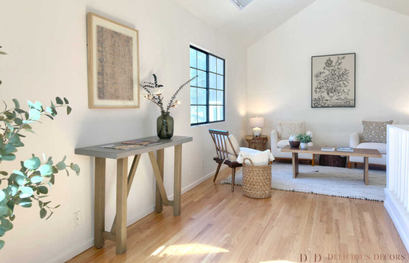 The home staging features modern furnishings, like a concrete top console table, along with traditional and farmhouse patterns.