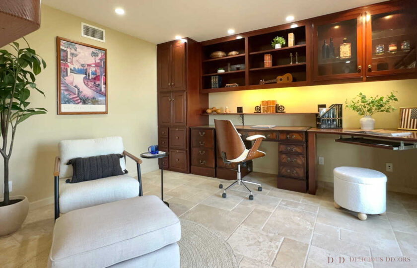The secret office is staged with a comfortable lounge chair, ottoman, desk chair, and plenty of interesting decor in the built-ins.