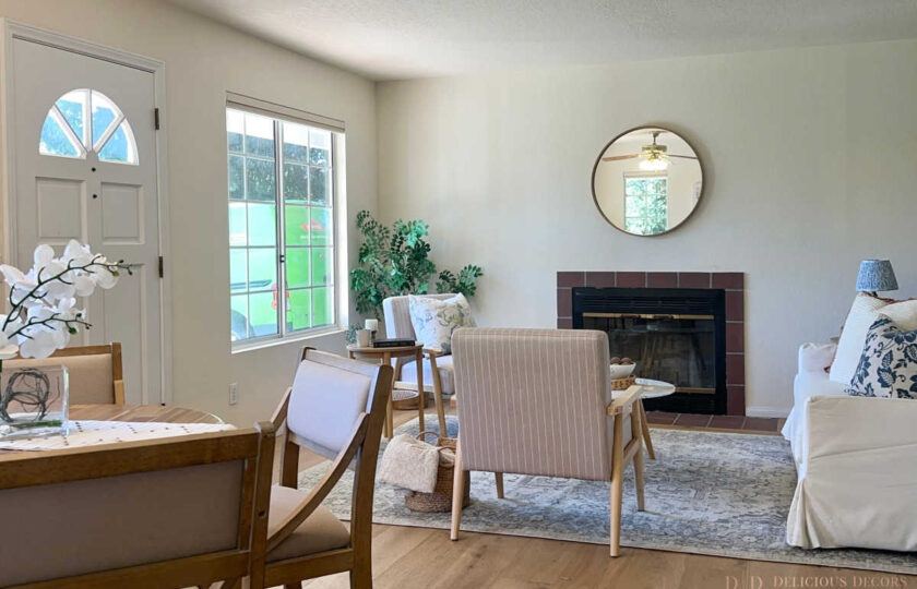 Santa Ynez luxury estate staging in the standalone guest house, showcasing a relaxed, cottage-inspired design with a white slipcovered sofa, striped armchairs, and a welcoming dining area.