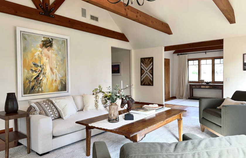 Santa Ynez estate staging highlighting a textured white sofa, an oversized knotty wood coffee table, and a large statement canvas in a vaulted living space.