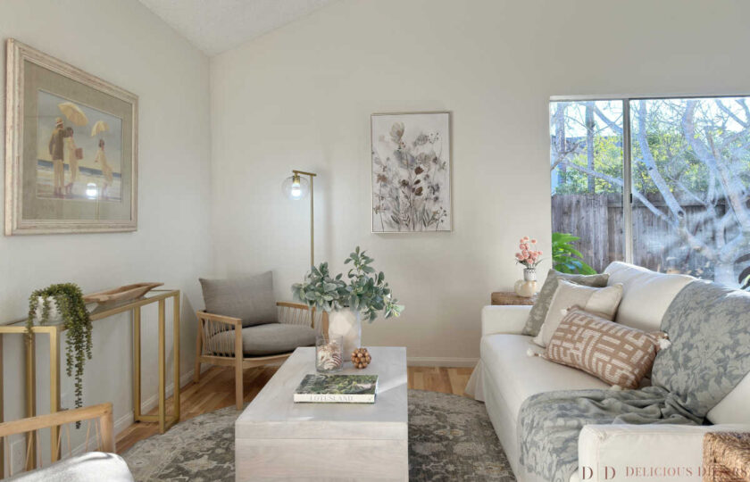 Comfort & Casual living room staging featuring a whitewashed wooden coffee table, soft patterned rug, gold console table, and woven accent armchairs.