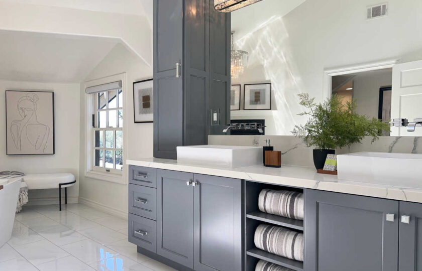 Luxury primary bath double vanity with slate grey cabinets, vessel sinks, white marble counters, and chrome fixtures.