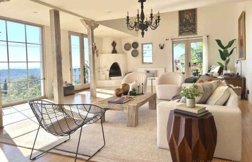 Beautifully staged Spanish Colonial living room on Mission Ridge with cream armchairs, exposed beams, wrought-iron chandelier, and panoramic ocean views.