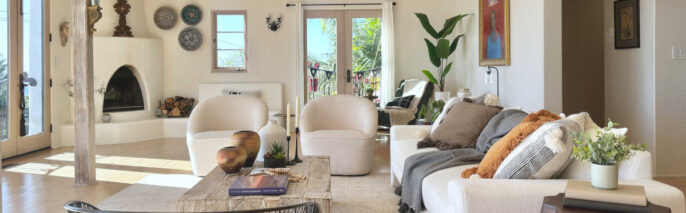 Bright living room showcasing expert Spanish Colonial staging, a kiva fireplace, neutral sofa, and natural wood accents in Santa Barbara.