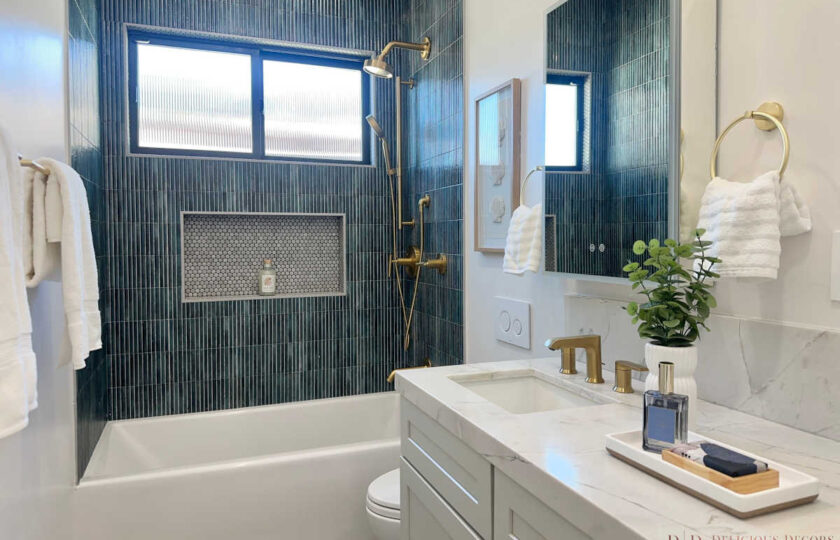 Staging Redondo Beach Modern Coastal featuring teal subway tile, marble vanity, gold fixtures, and shower niche.