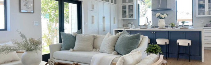 Staging Redondo Beach Modern Coastal showing white sofa, neutral accents, and wide view of navy kitchen island.