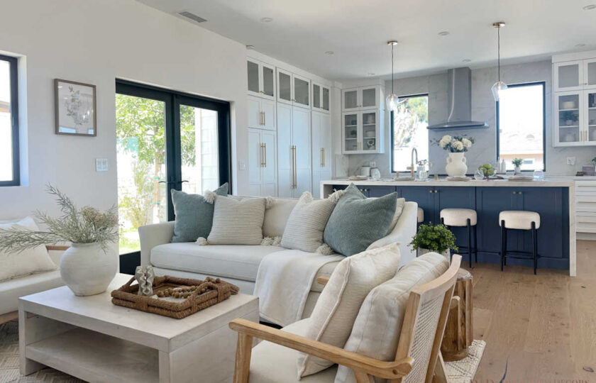 Staging Redondo Beach Modern Coastal showing white sofa, neutral accents, and wide view of navy kitchen island.
