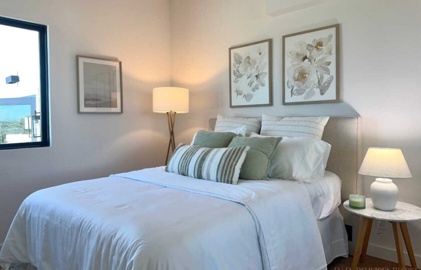 Staging Redondo Beach Modern Coastal with upholstered bed, crisp white linens, gold accents, and floral wall art.