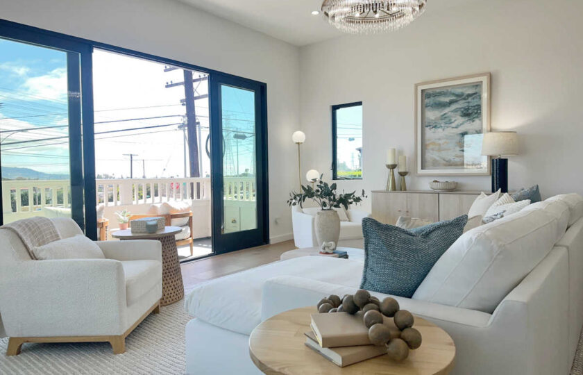 Staging Redondo Beach Modern Coastal with large white sectional, ocean-inspired artwork, and round coffee table.