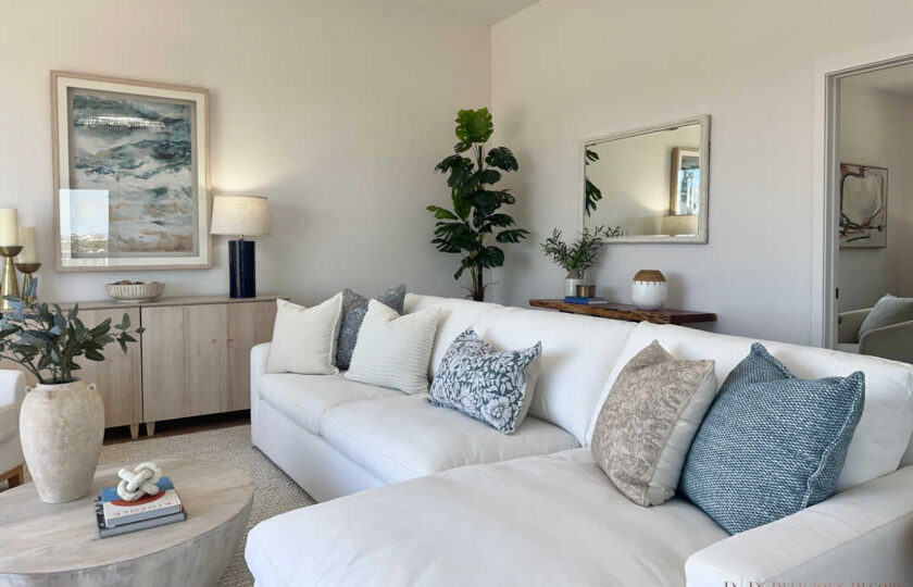 Staging Redondo Beach Modern Coastal with white sectional, muted blue pillows, oak sideboard, and ocean art.