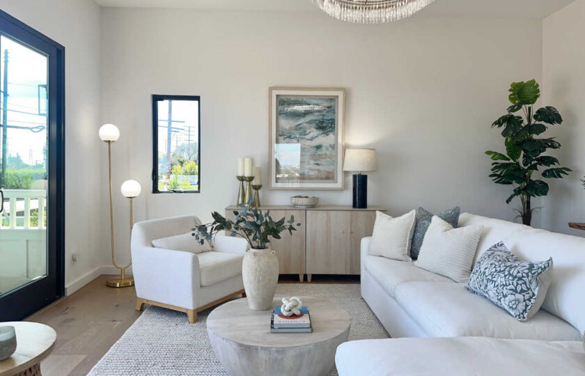 Staging Redondo Beach Modern Coastal featuring bouclé armchair, brass floor lamp, light credenza, and coffee table.