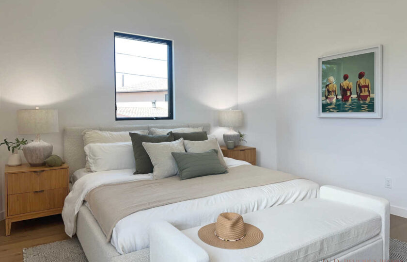 Redondo Beach Modern Coastal with white bedding, olive pillows, wood nightstands, and swimmer art print.