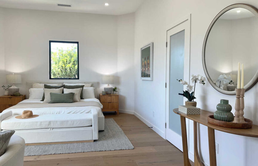 Staging Redondo Beach Modern Coastal featuring wood console table, round mirror, and open primary bedroom layout.