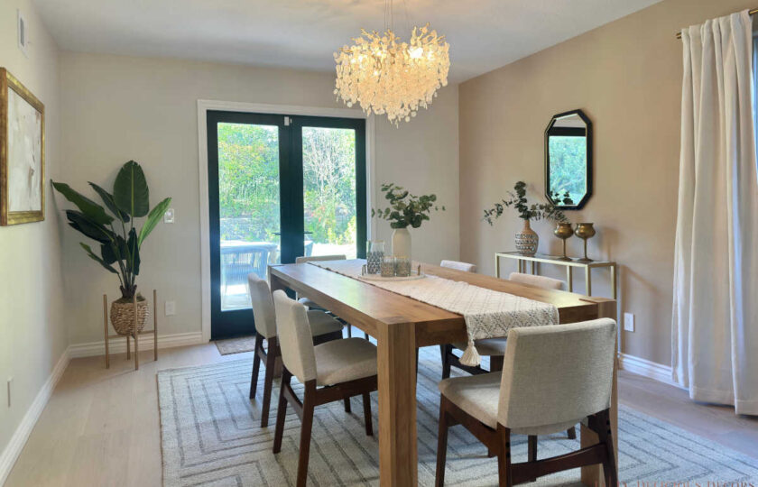 Elegant dining room staging featuring a solid wood dining table, cream upholstered chairs, a capiz shell chandelier, and French doors leading outdoors.