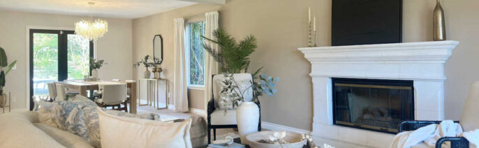 Westlake Village Home Staging showcasing a high-ceiling living room with a white stone fireplace, curved boucle sofa, and open flow into a staged dining area.