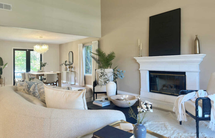 Westlake Village Home Staging showcasing a high-ceiling living room with a white stone fireplace, curved boucle sofa, and open flow into a staged dining area.