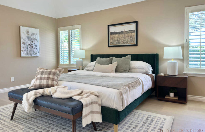 Primary bedroom suite staging featuring a deep green velvet bed frame, white ceramic lamps, a leather bench, and warm neutral walls in Westlake Village.