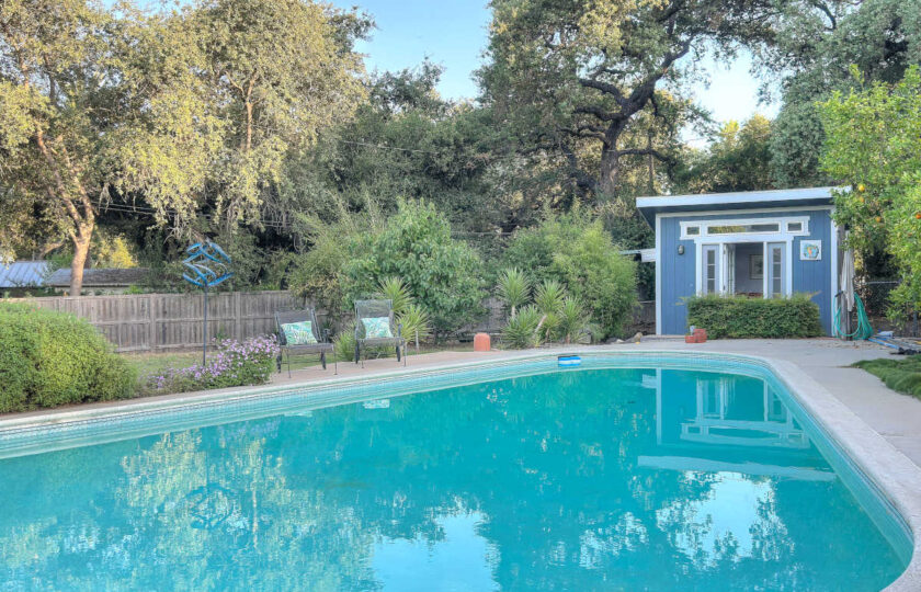 Outdoor swimming pool and staged detached pool house at an authentic 1957 Ojai mid-century modern ranch estate.